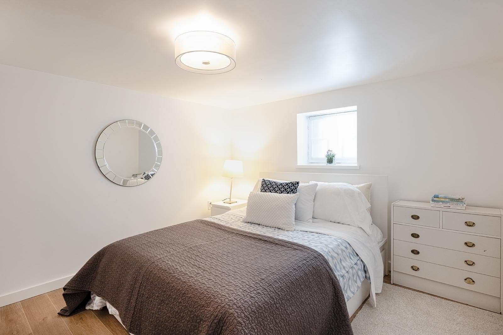 Cozy modern bedroom with white walls, minimalist decor, and natural light, perfect for Vancouver real estate listings and home staging by Orca Realty Inc.
