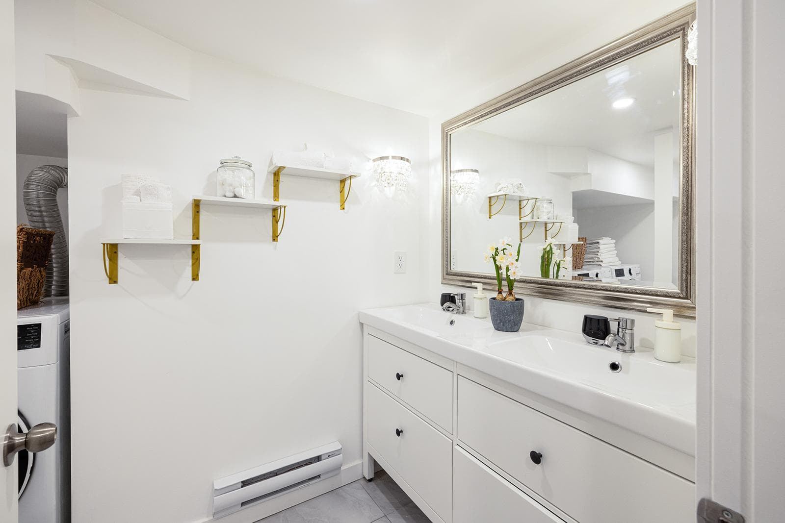 Bright white bathroom with dual sink vanity, large wall mirror, modern fixtures, and stylish decor, perfect for comfortable living and home resale.