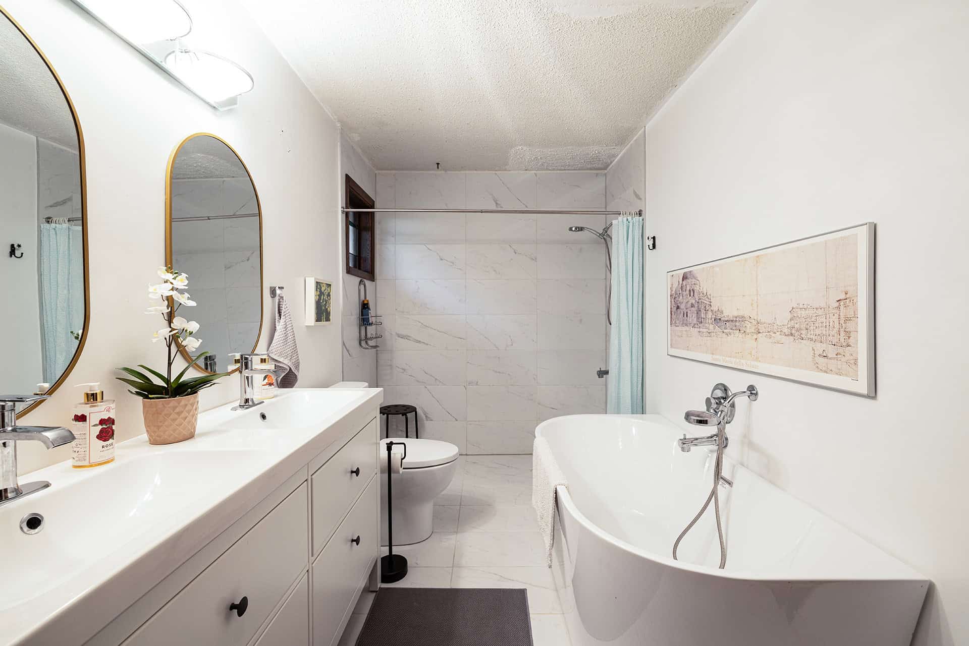 Modern bathroom with double vanity, free-standing bathtub, walk-in shower, and elegant decor, ideal for luxury living in Vancouver, BC. Features marble tiles, contemporary fixtures, and natural light.