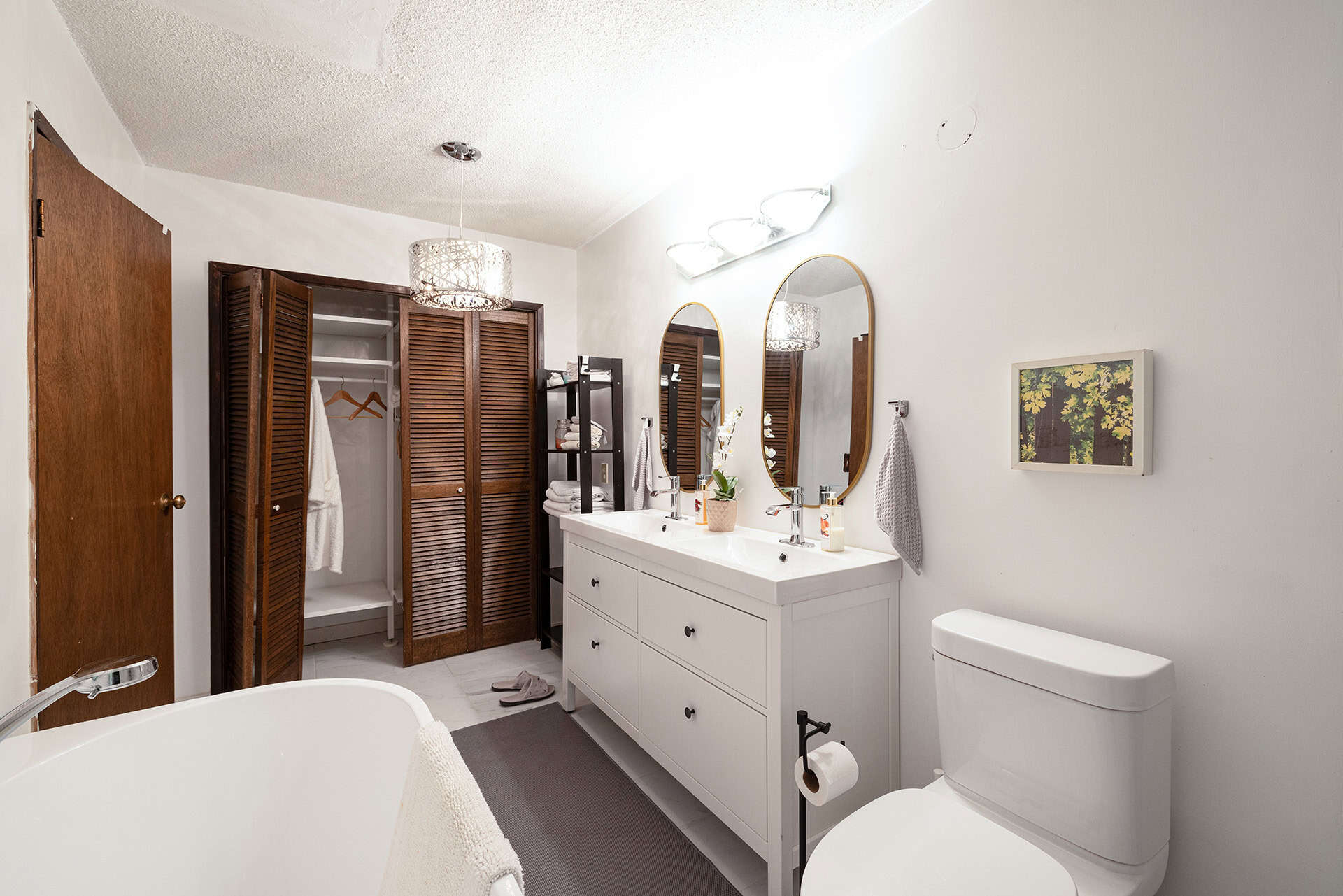 Bright modern bathroom with dual sinks, white cabinetry, wooden accents, and a stylish bathtub—ideal for Vancouver-area homes listed with Orca Realty Inc.