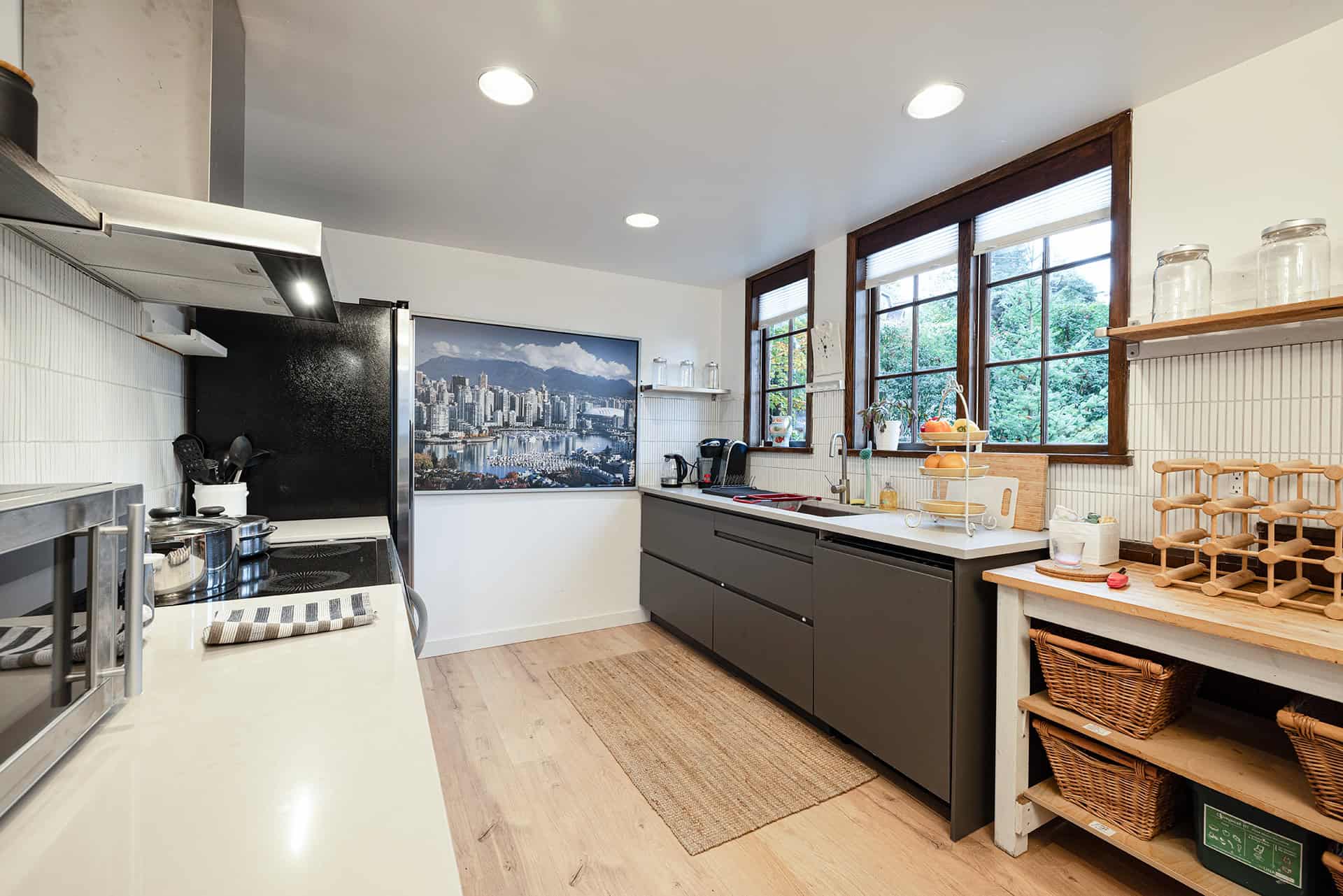 Modern Vancouver-style kitchen with large windows, stainless steel appliances, and sleek dark cabinetry. Bright, cozy, and perfect for family cooking and entertaining.
