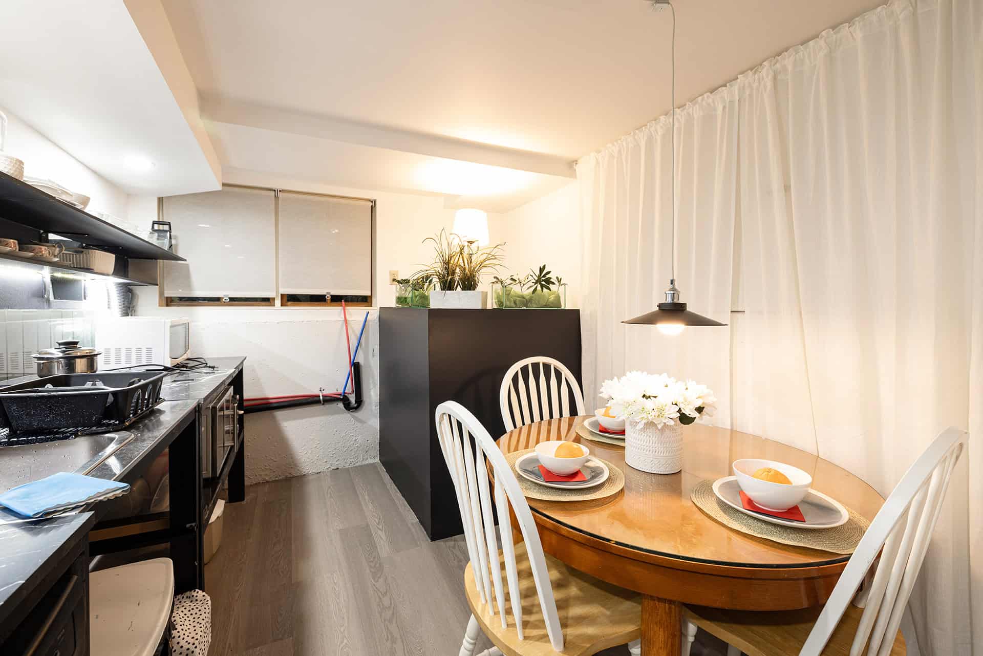 Modern kitchen and dining area with sleek appliances, cozy decor, and contemporary furnishings, perfect for Vancouver Island homebuyers seeking comfort and style.