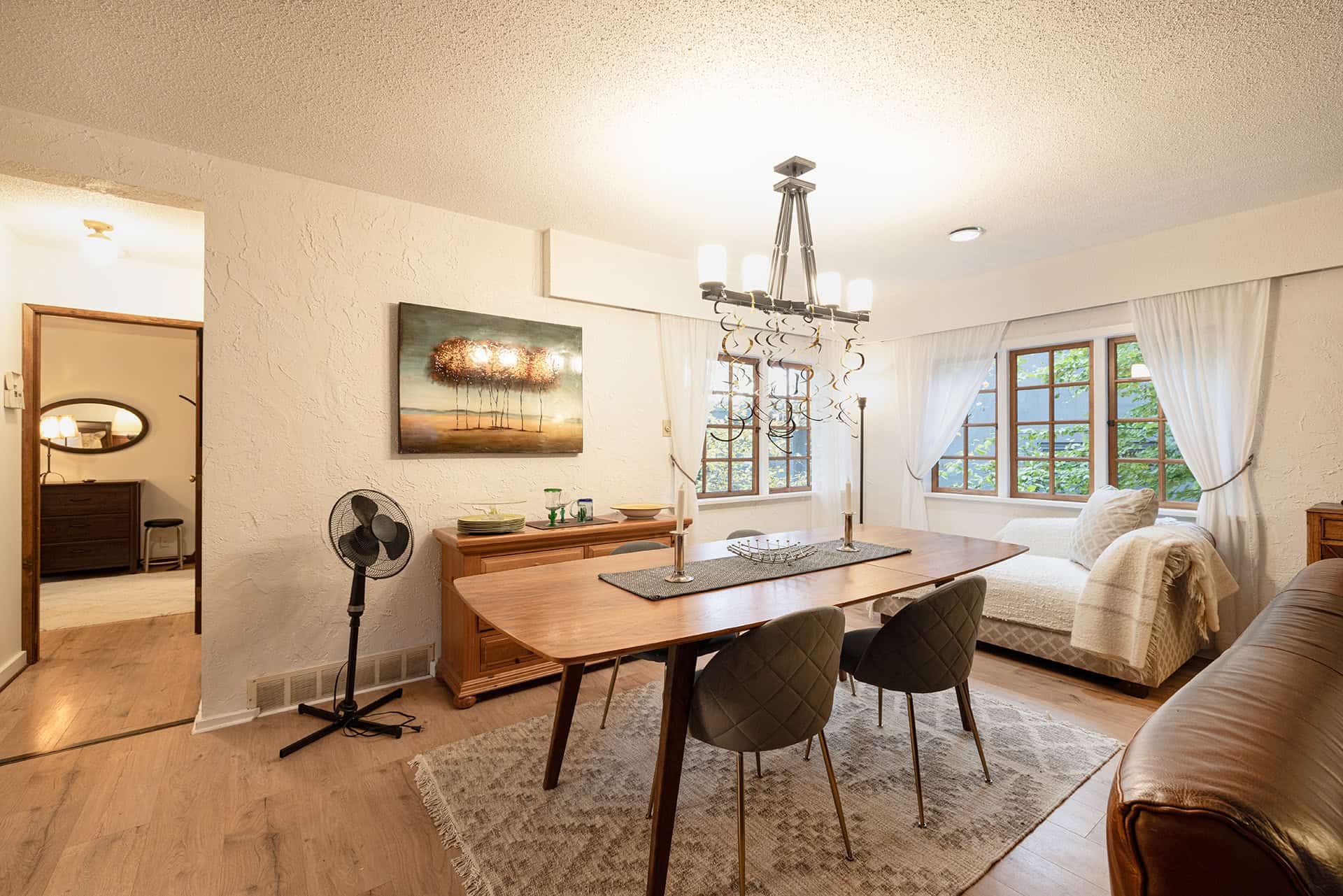 Spacious interior of a Vancouver home showing a bright dining area and cozy living space with large windows, modern decor, and natural light, highlighting real estate opportunities.