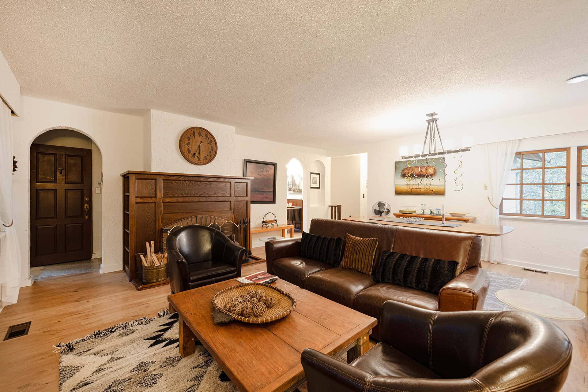 Cozy living room with white textured walls, wooden accents, and modern decor, showcasing Orca Realty Inc.'s expertise in Vancouver Island real estate.