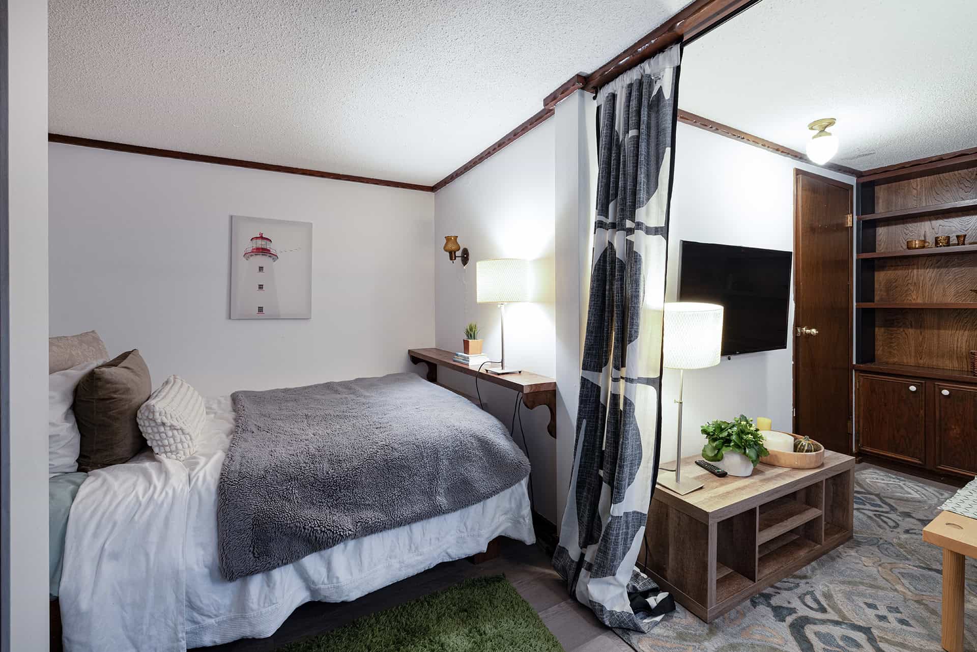 Cozy bedroom with modern decor, comfortable bedding, and stylish furnishings at Orca Realty Inc., ideal for Vancouver Island real estate buyers seeking a peaceful home.