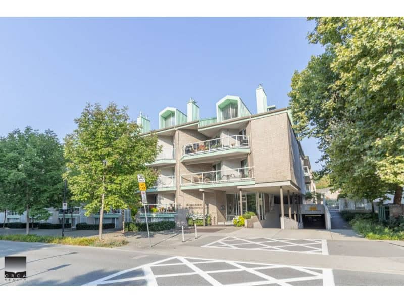 Spacious modern condominium building with balconies and green rooftop structures, located in a green neighbourhood, ideal for Vancouver real estate investment or condo living in Canada.