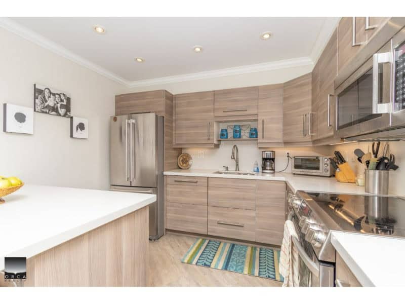 Modern kitchen with light wood cabinetry, stainless steel appliances, and ample counter space, ideal for comfortable living.