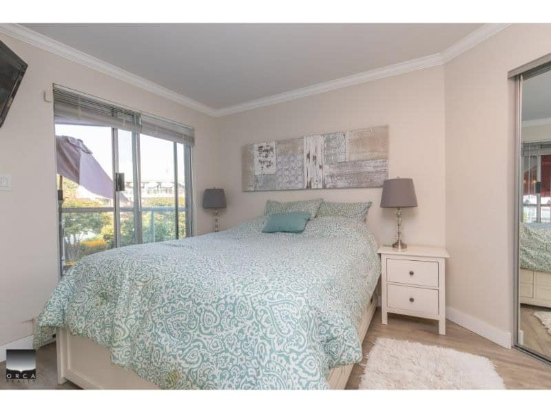 Bright bedroom with large windows, modern decor, and abundant natural light in a Vancouver home. Perfect for real estate listings highlighting comfortable and stylish interior spaces.