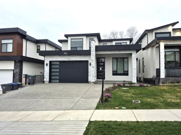 Contemporary modern house exterior with stylish black and white facade, spacious driveway, and landscaped front yard – ideal for Vancouver real estate listings.