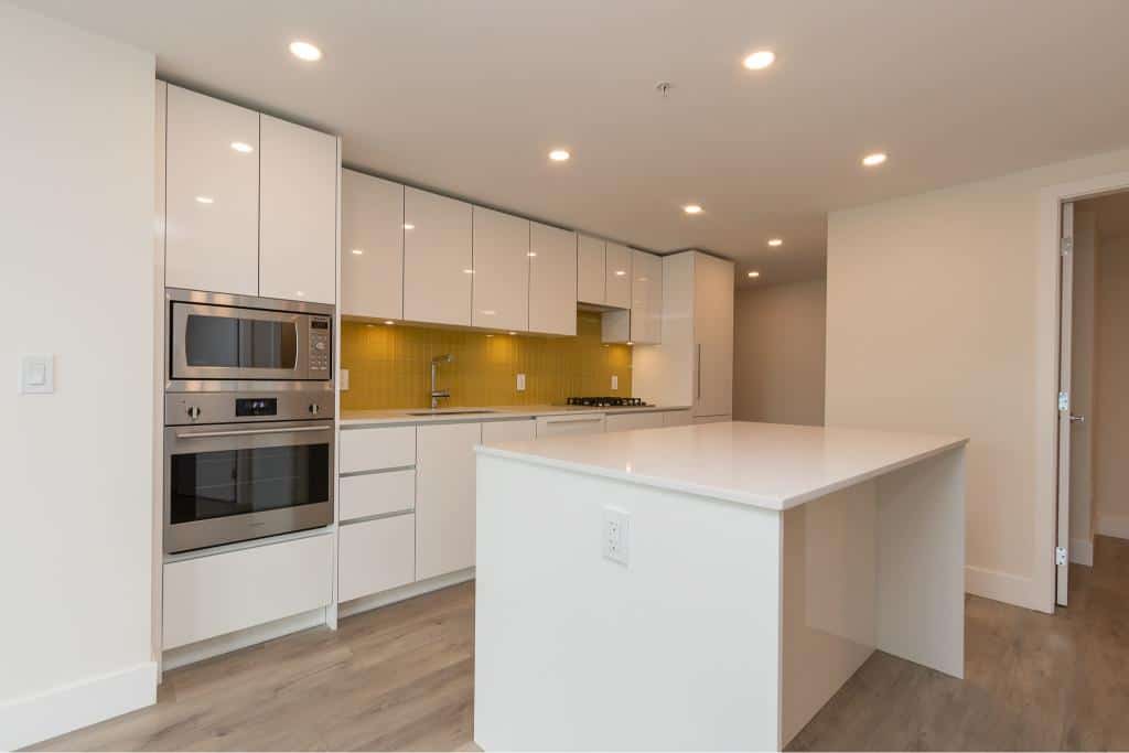 Modern white kitchen with sleek cabinetry and stainless steel appliances, perfect for Vancouver real estate and home buyers.