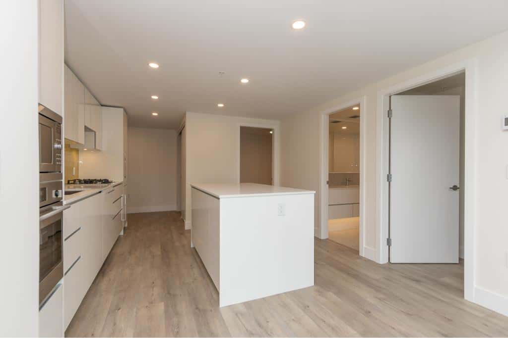 Modern kitchen with sleek white cabinetry and stainless steel appliances, perfect for Vancouver real estate buyers.