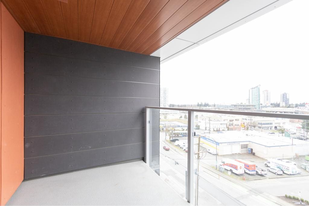 Modern balcony with glass railing overlooking urban cityscape, featuring contemporary architecture and city views in Vancouver, BC. Ideal for real estate listings showcasing downtown Vancouver properties.