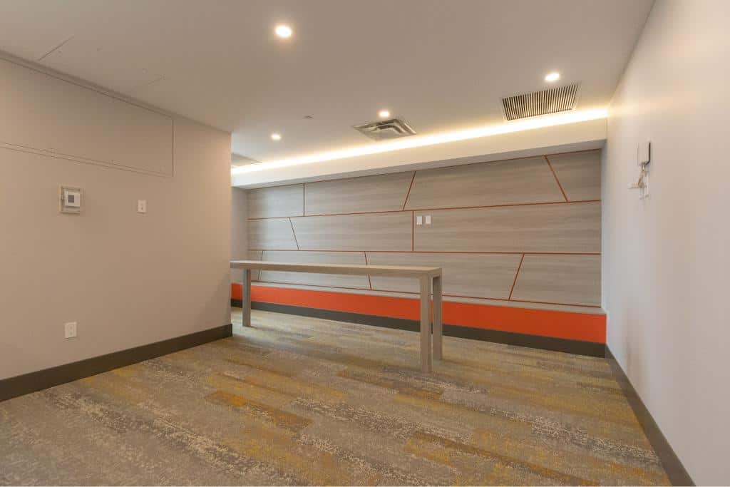 Modern indoor space with contemporary design, neutral colours, and stylish wood accent wall, perfect for real estate showcasing or office use.