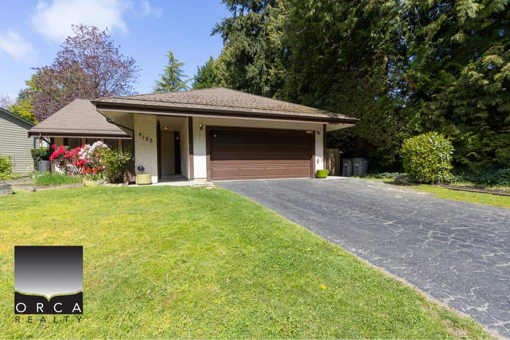 Charming single-family home in a peaceful neighbourhood, featuring a spacious driveway, lush front lawn, and attractive exterior perfect for families and investors in the Greater Vancouver real estate market.