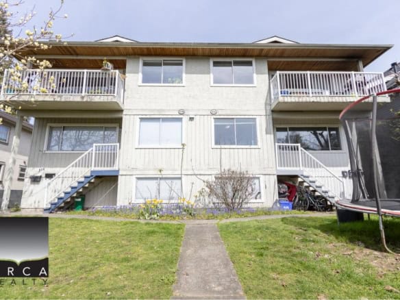 Bright multi-family residential building with balconies on each floor in a peaceful neighborhood. Ideal for real estate investors or families looking for Vancouver properties.
