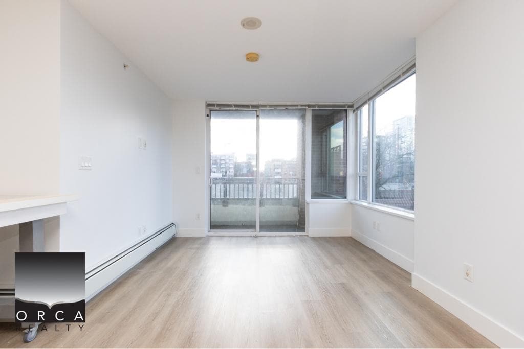 Bright, spacious interior of a Vancouver condo at 407-231 E Pender St, featuring large windows and natural light.
