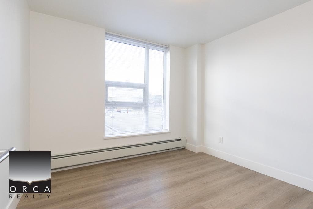 Spacious, bright living room with large window and hardwood flooring in Vancouver condo at 407-231 E Pender St, offered by Orca Realty Inc.