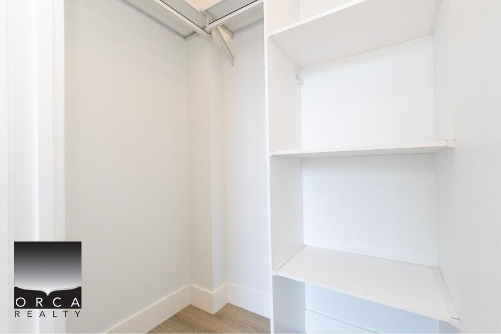 Closet interior with white shelves and hanging space in Vancouver condo near 407-231 E Pender St.