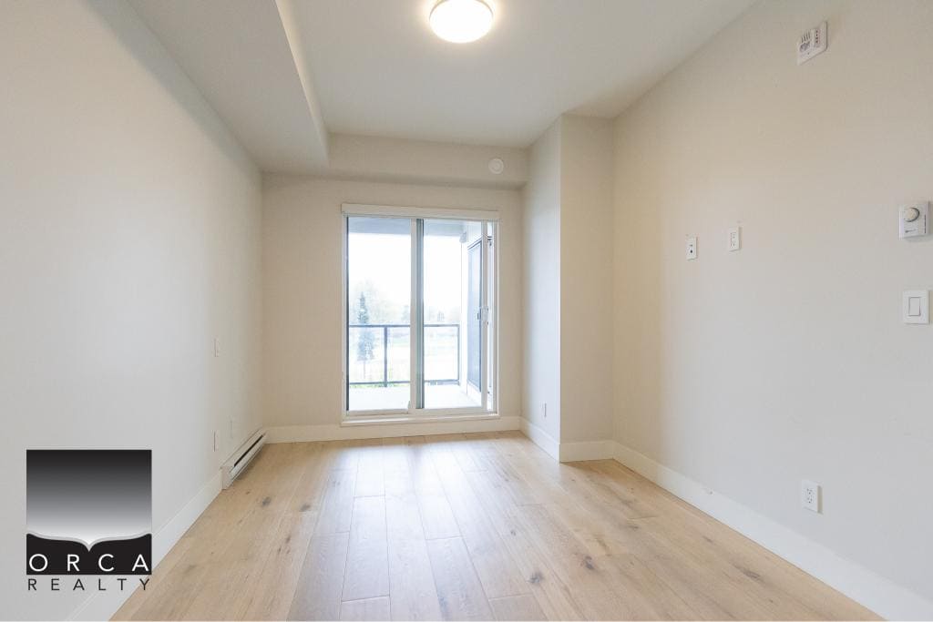Spacious modern apartment interior with natural light, hardwood floors, and balcony access, ideal for Vancouver real estate buyers seeking contemporary condos.