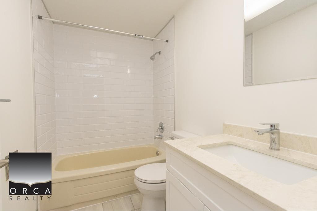 Modern beige bathtub and white tiled shower in a contemporary bathroom with minimalist design.