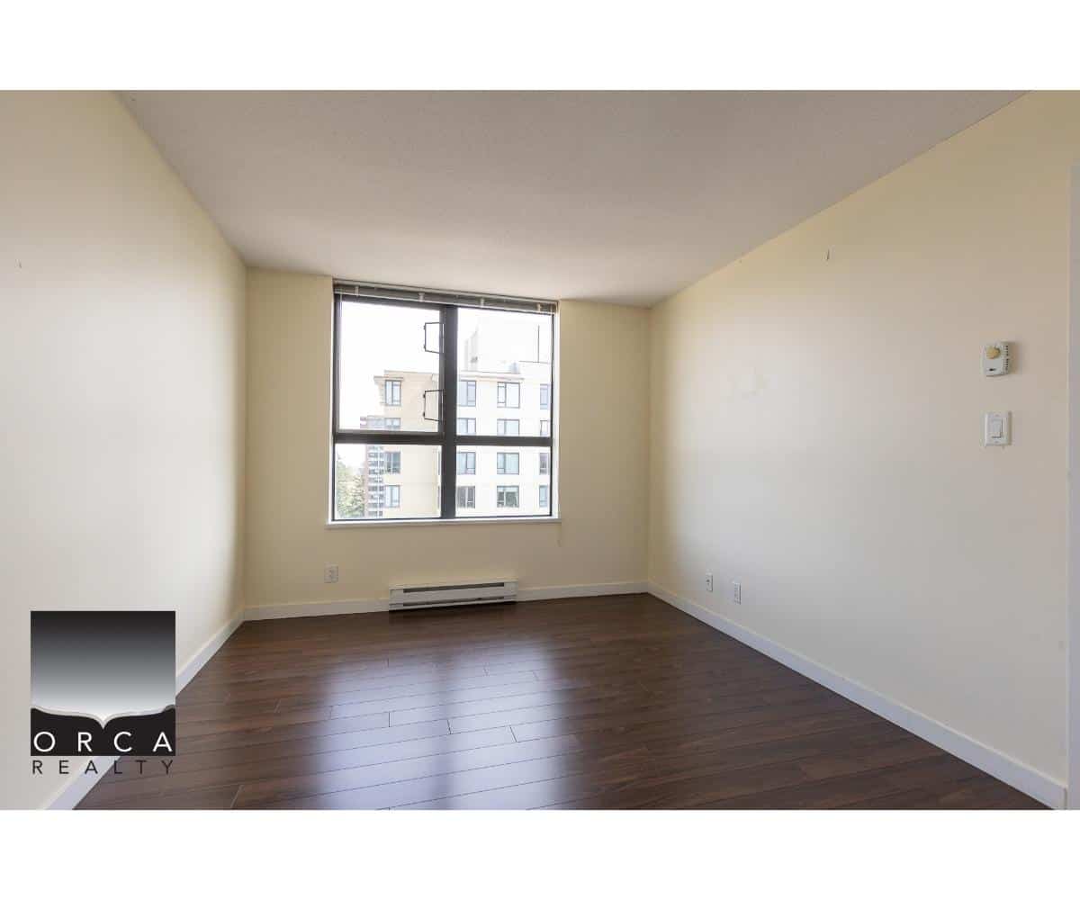 Bright empty living room with large window in modern apartment for sale or rent by Orca Realty Inc. in Vancouver, BC.