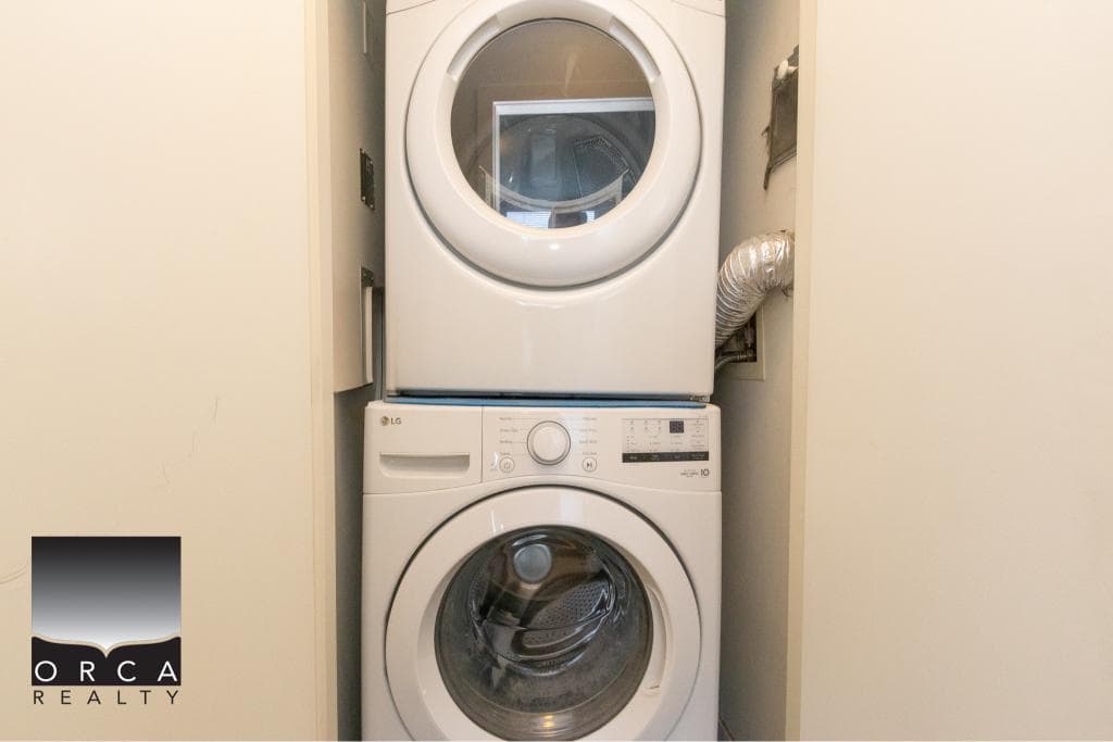 Efficient stacked washer and dryer in a compact laundry space at 407-231 E Pender St, Vancouver. Perfect for convenient home living and property value enhancement.