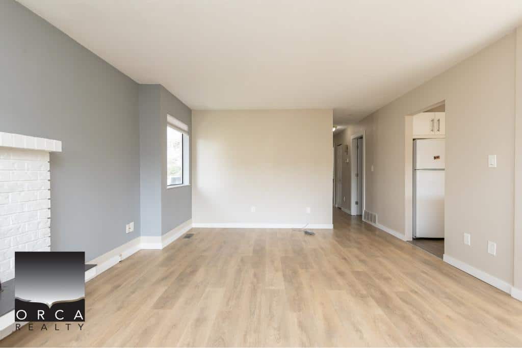 Bright and spacious living room with modern updates in a Vancouver Island home, featuring hardwood floors, large windows, and an open layout perfect for family living and entertaining.