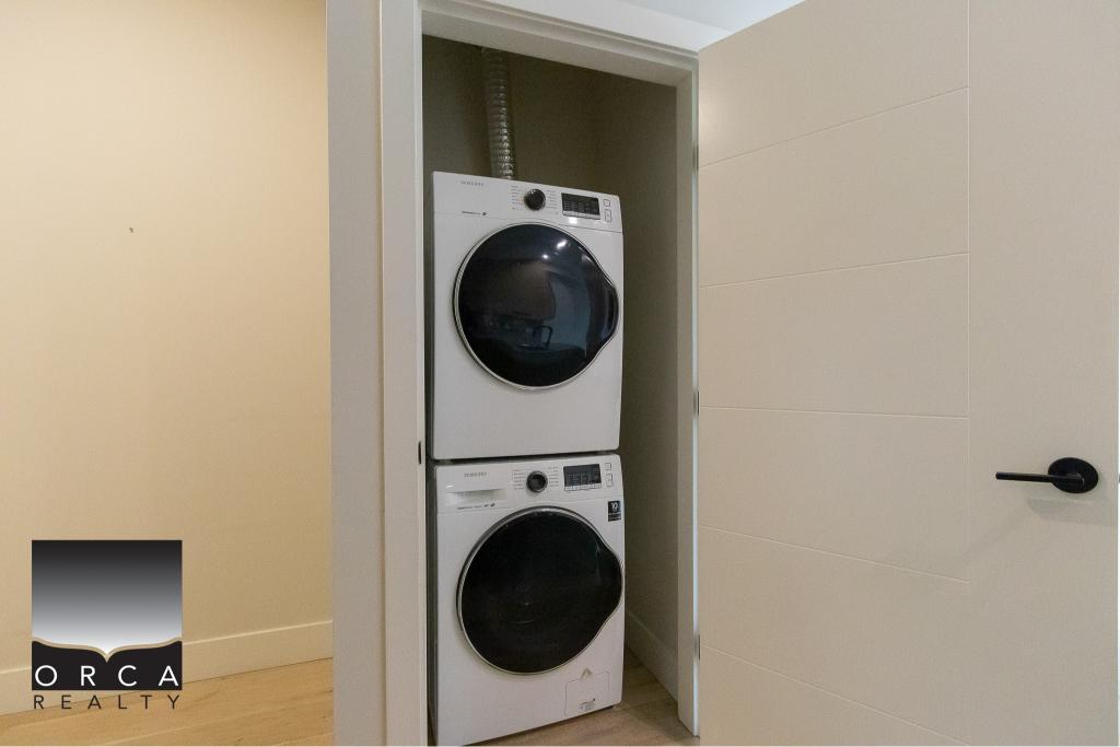 Stacked washer and dryer in a modern laundry closet, ideal for condominium or apartment living in Vancouver. Conveniently located, stylishly integrated with neutral wall finishes for easy maintenance.