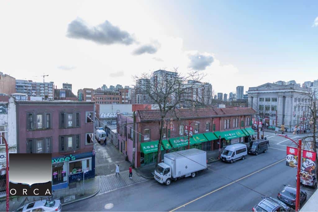 Bright street view of 407 E Pender St in Vancouver, showcasing local shops and urban surroundings.