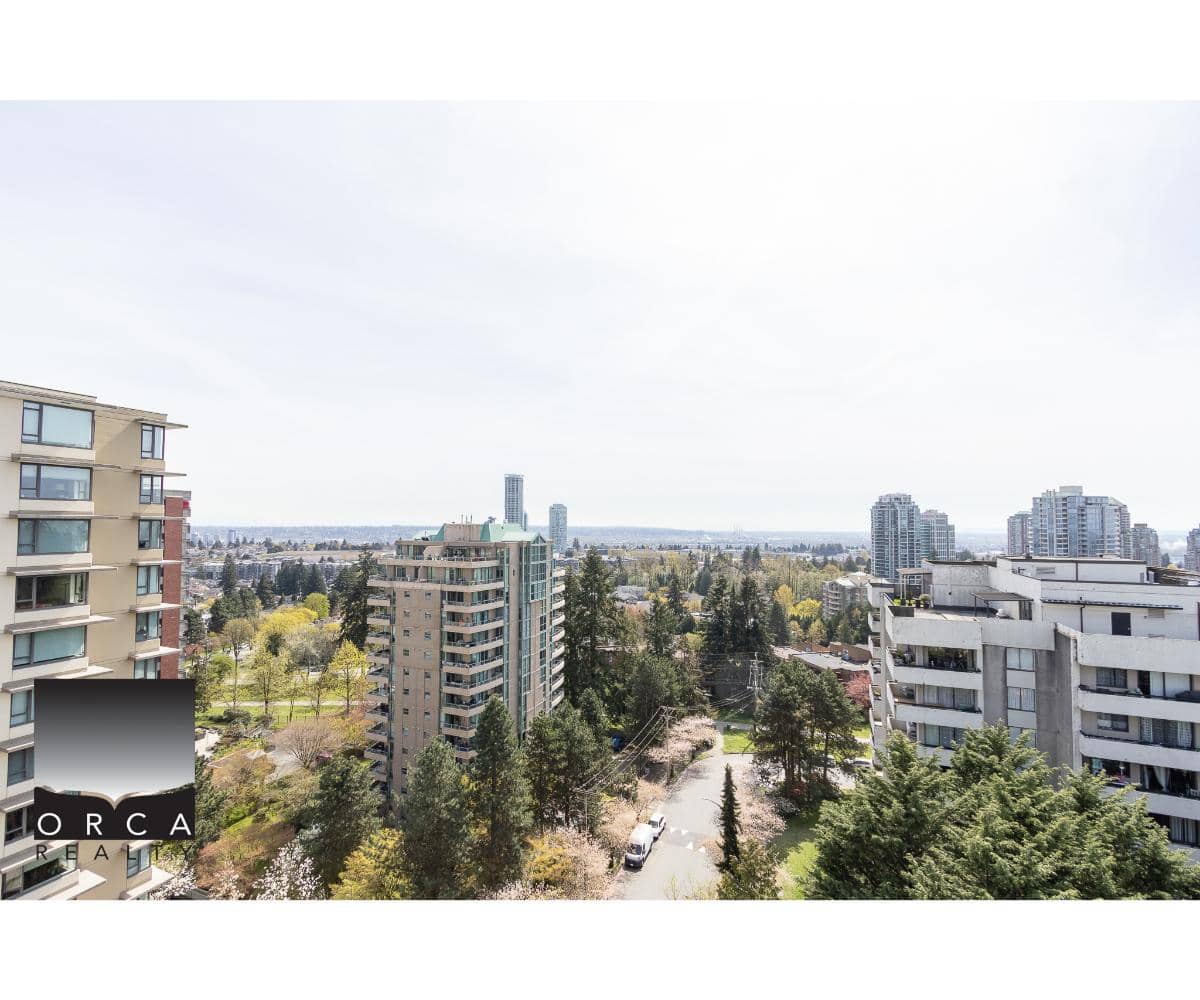 Aerial view of Vancouver cityscape with modern high-rise condos, lush green trees, and clear skies, showcasing prime real estate opportunities in Vancouver's vibrant urban environment.