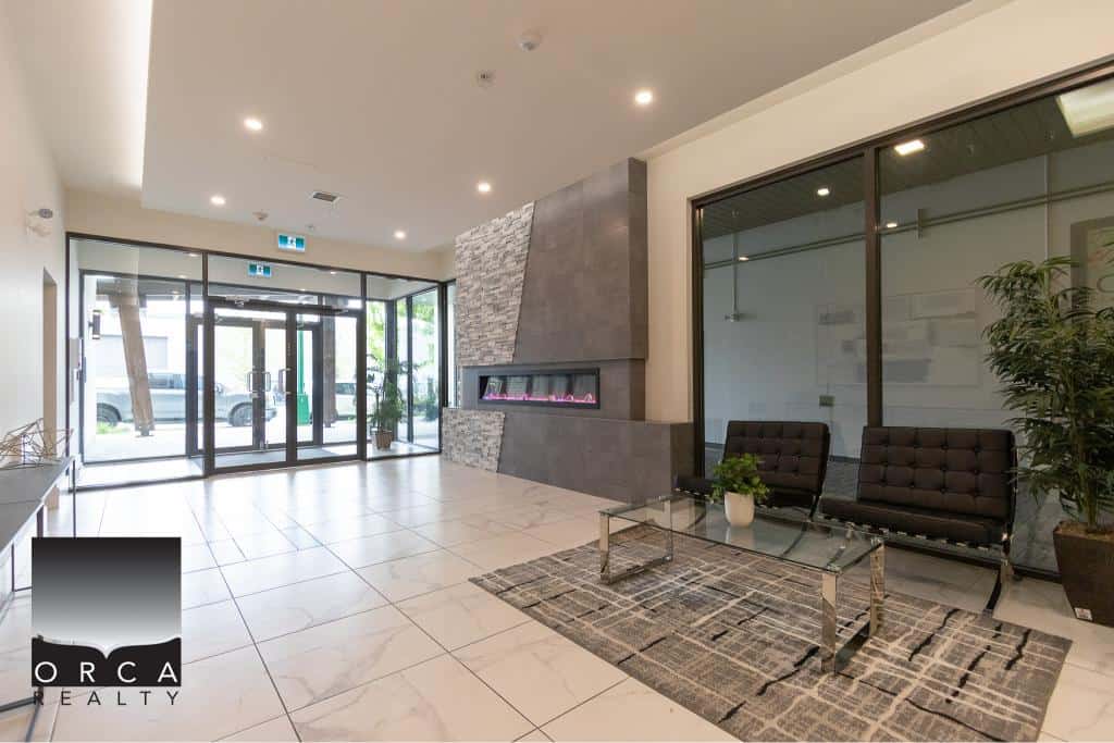 Spacious modern lobby of Orca Realty Inc. featuring contemporary decor, cozy seating area, and stylish fireplace, ideal for clients and visitors in a professional real estate office environment.