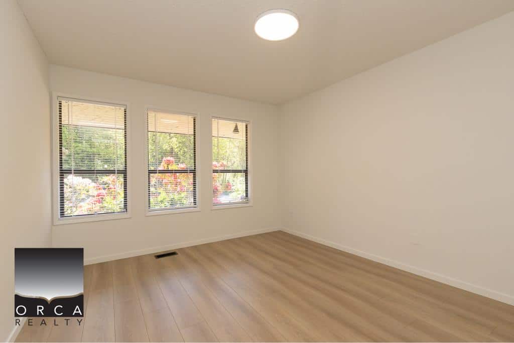 Bright empty room with three large windows and natural light, ideal for home staging, in a Vancouver property listed by Orca Realty Inc., a trusted Vancouver real estate company.