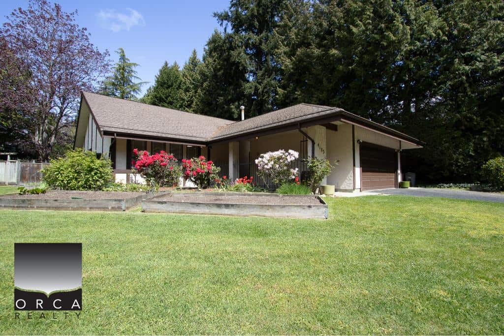 Bright single-family home with lush landscaping and garden beds, perfect for families seeking a peaceful neighbourhood. Beautiful yard and serene outdoor space highlight this Orca Realty Inc. listing.