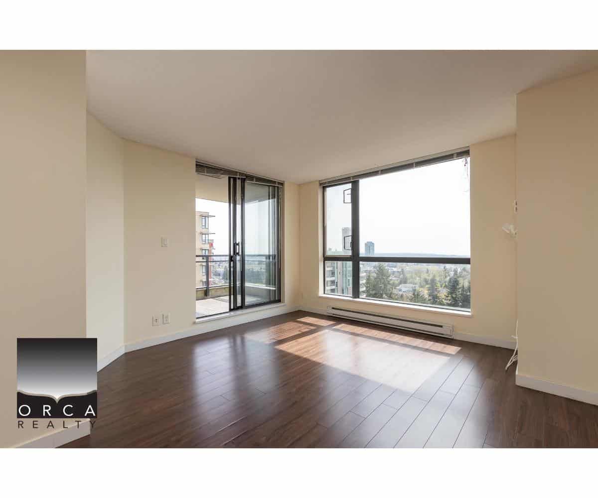 Bright modern condo living room with large windows, city views, and hardwood floors, ideal for Vancouver real estate buyers and investors seeking Downtown Vancouver apartments.