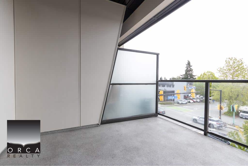 Modern balcony view with glass railing overlooking busy street, ideal for Vancouver real estate buyers seeking condos or apartments in desirable locations.