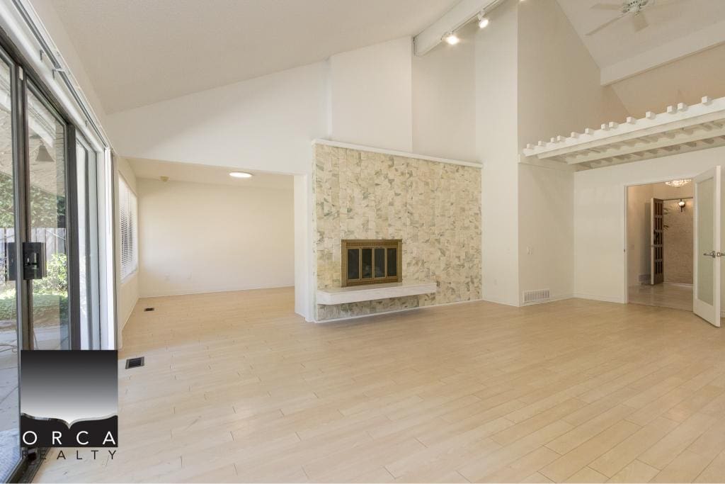 Modern living room with stone fireplace and vaulted ceiling, ideal for Vancouver Island homes, featuring bright natural light and open-concept design. Perfect for real estate listings.