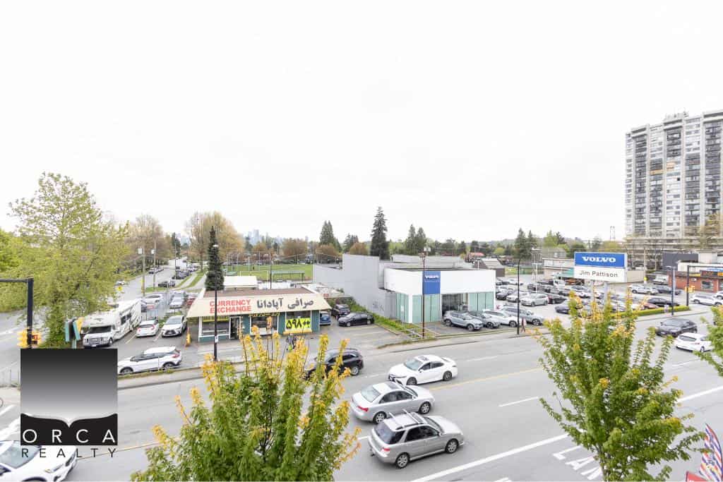 Vibrant street view of commercial real estate and busy parking lot in Vancouver BC showcasing Orca Realty Inc.'s real estate expertise.