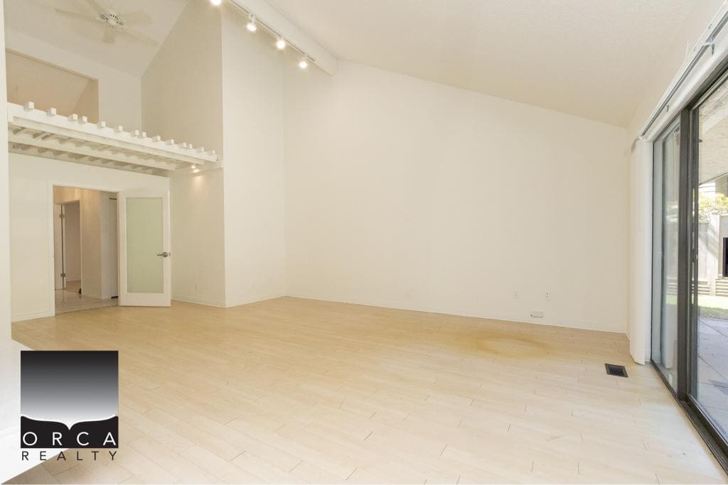 Bright, spacious living room with large sliding glass doors, hardwood flooring, and modern interior design - ideal for Vancouver Island real estate and property sales.
