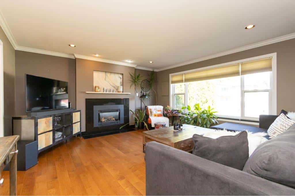 Cozy living room with modern fireplace, flat-screen TV, and stylish decor in a Vancouver area home for real estate listing by Orca Realty Inc.