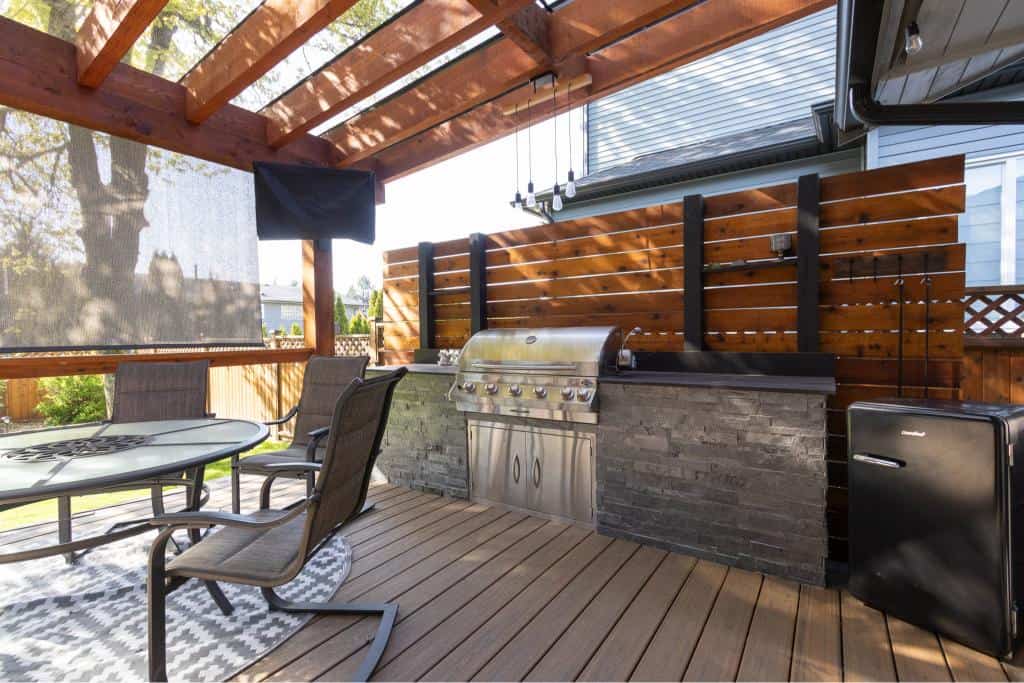 Outdoor deck with built-in BBQ, patio furniture, and wooden privacy fencing for Vancouver Island homes. Perfect for entertaining and outdoor living.