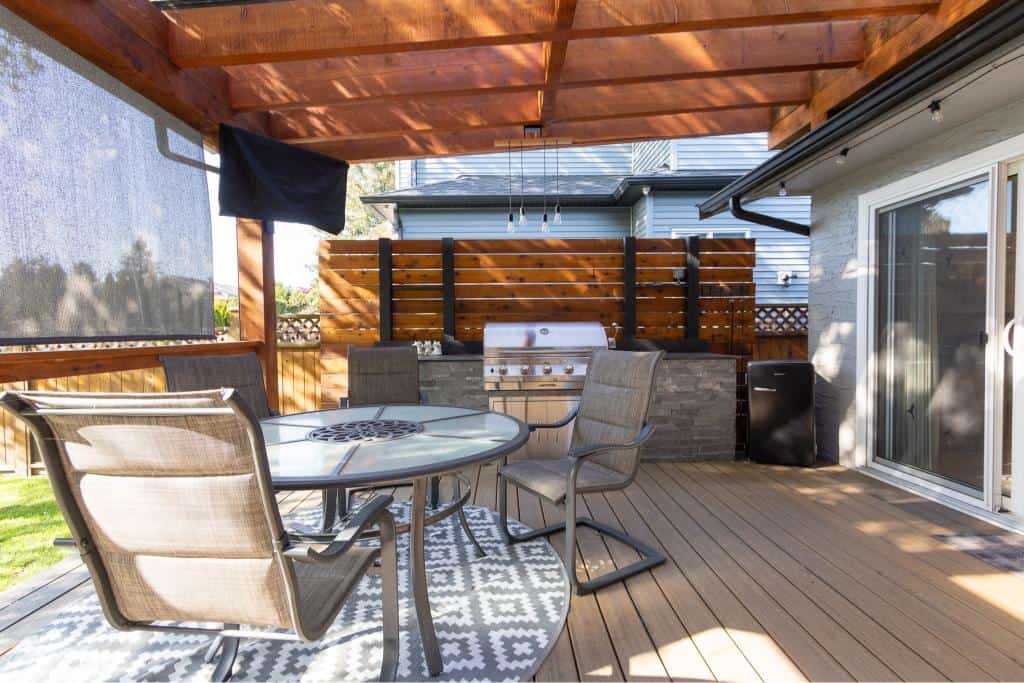 Modern outdoor patio with dining area and BBQ grill at Orca Realty Inc. property in Vancouver, BC. Perfect for entertaining guests or relaxing outdoors.
