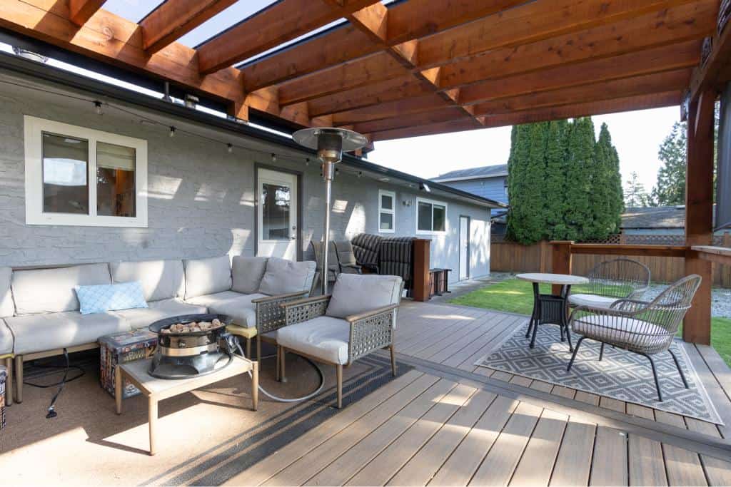 Modern outdoor patio with cozy seating area, patio heater, and wooden pergola, perfect for backyard entertaining and relaxation in Vancouver, BC.