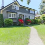 Beautiful front yard of a charming residential home in Vancouver, BC, showcasing lush green lawns, vibrant landscaping, and inviting entryway, ideal for real estate and property buyers.
