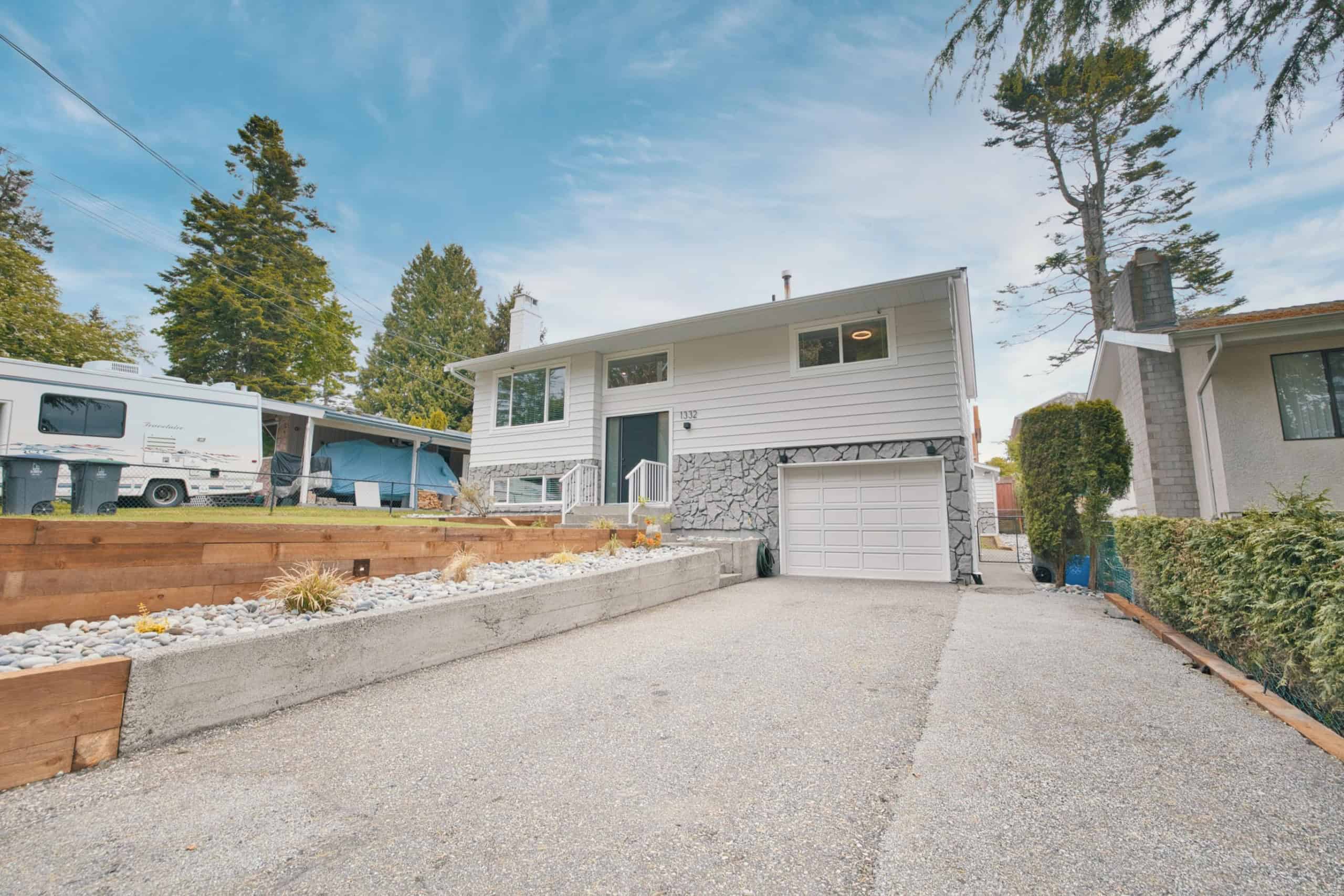 Spacious suburban house with a well-maintained driveway, modern exterior, and inviting front entrance, ideal for family living and real estate investment.