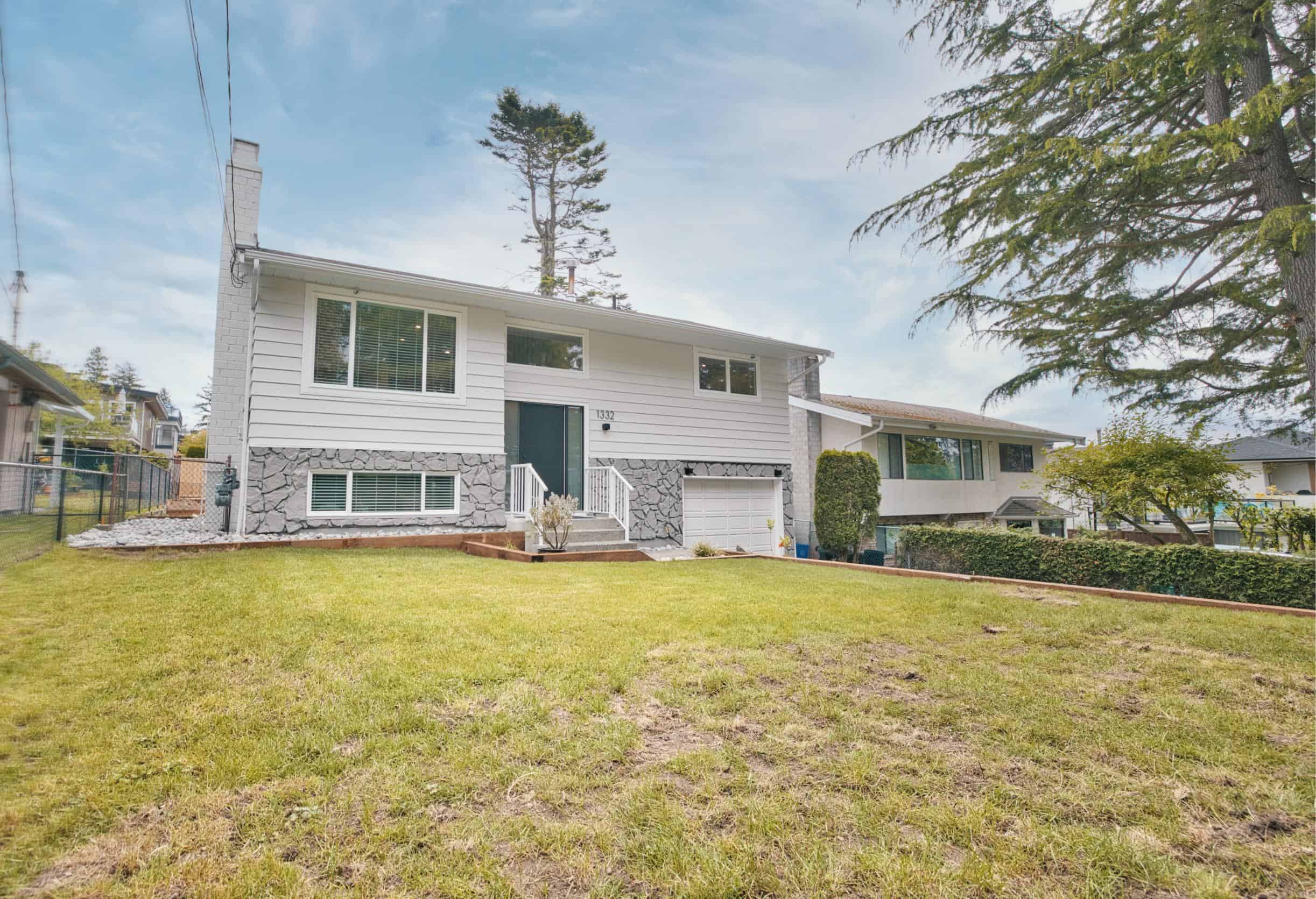 Spacious suburban house with well-maintained lawn, modern exterior, and double garage, showcased by Orca Realty Inc. in Vancouver, BC. Perfect family home with charming curb appeal and plenty of outdoor space.