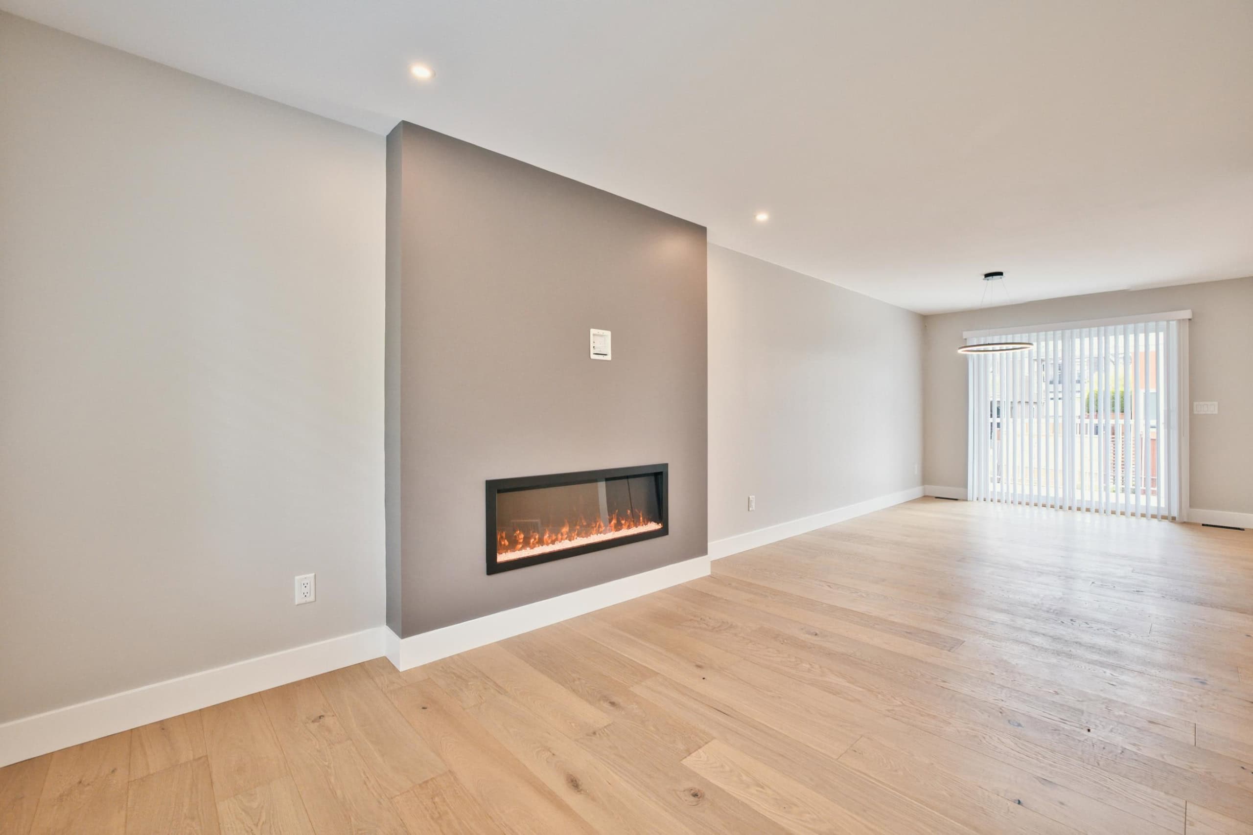 Modern open-concept living room with a sleek linear fireplace and spacious layout, perfect for Vancouver real estate listings and contemporary home sales.