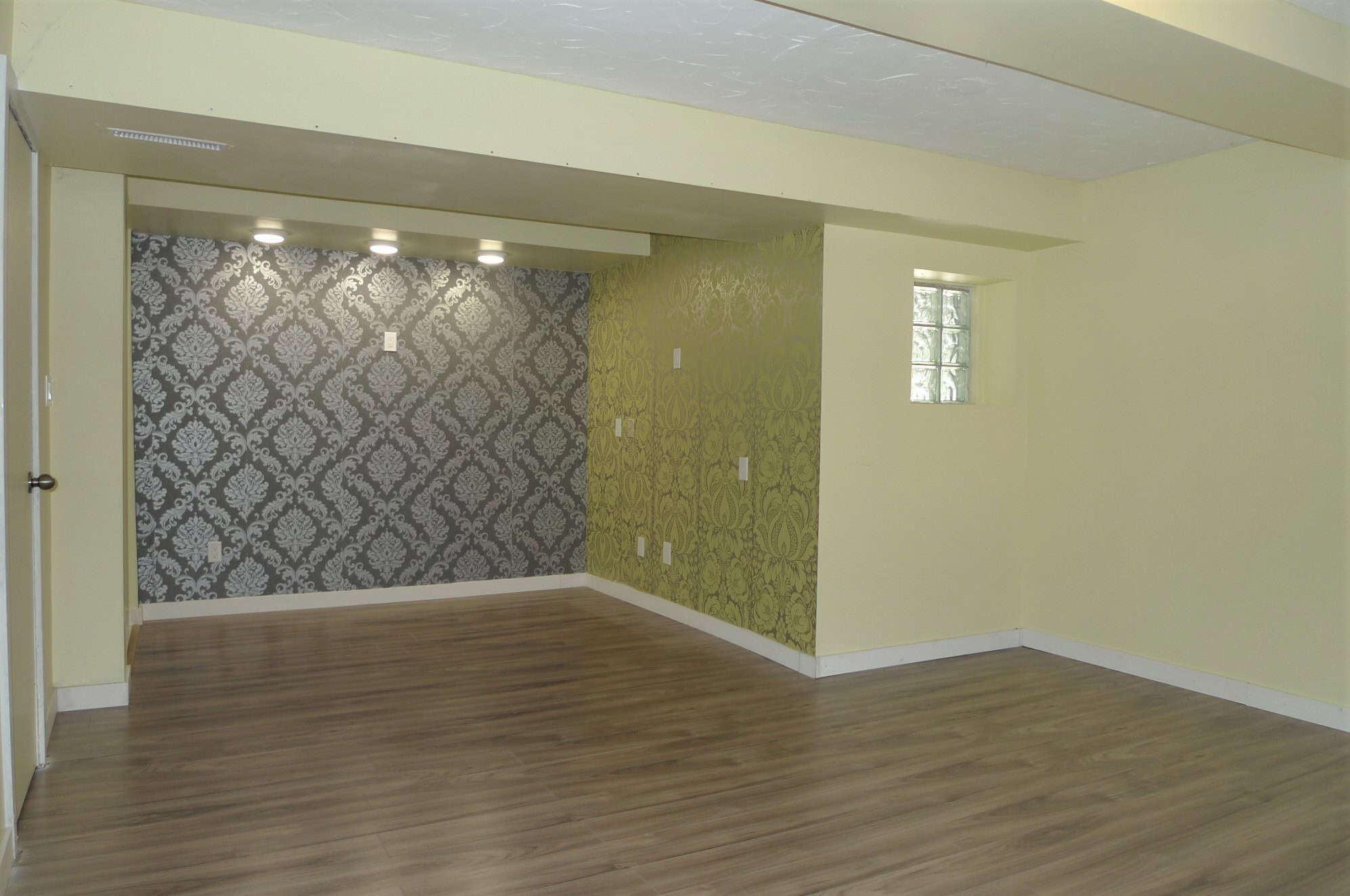Modern interior living room with patterned accent walls and hardwood flooring, ideal for family or entertaining in Victoria, BC.