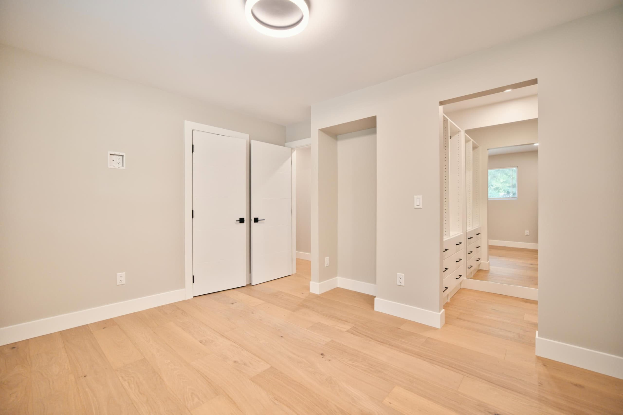 Bright, modern interior of a newly renovated home showcasing light-colored walls, hardwood flooring, and custom built-in storage, ideal for Vancouver-area real estate listings.