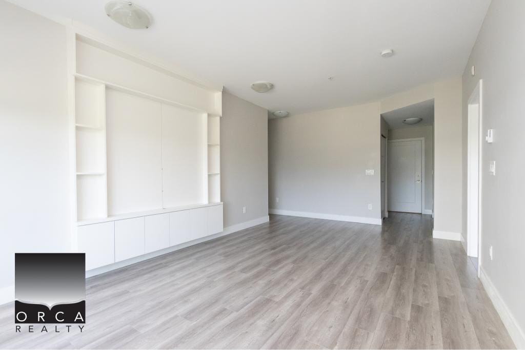 Bright, modern living room with neutral tones, built-in shelving, and laminate flooring, ideal for Vancouver housing market.