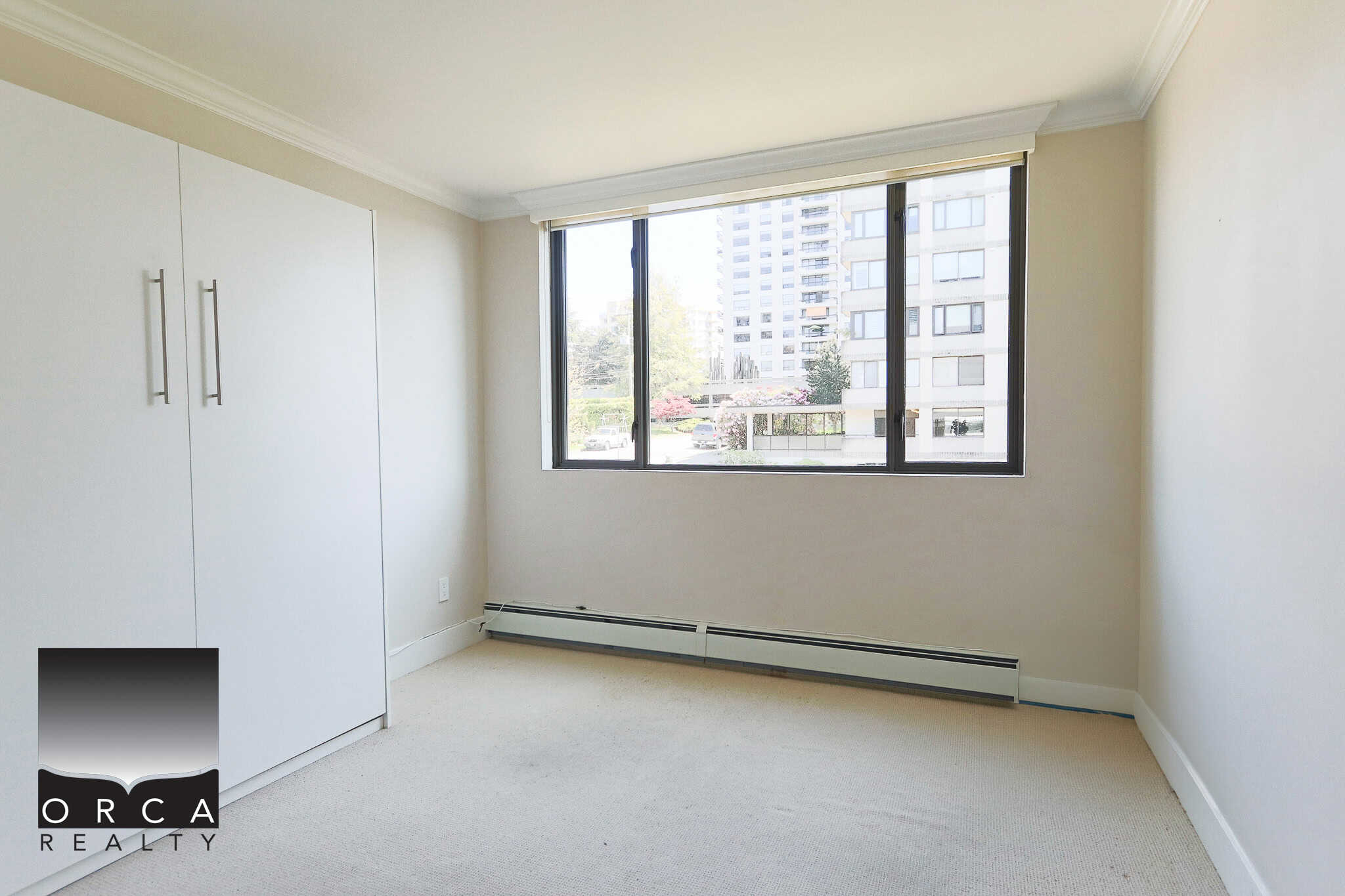 Bright and spacious bedroom in a modern apartment with large windows, ample natural light, and neutral decor, perfect for living in Vancouver's prime real estate area.